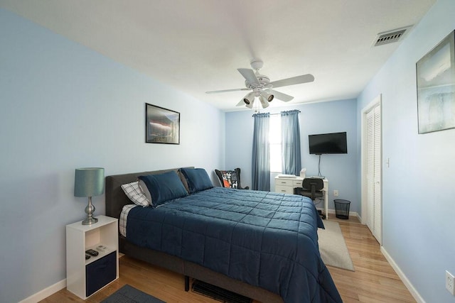 bedroom with ceiling fan, a closet, and light hardwood / wood-style flooring