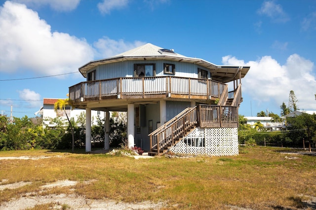 rear view of property with a wooden deck and a lawn