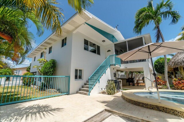 rear view of property featuring a swimming pool and a patio