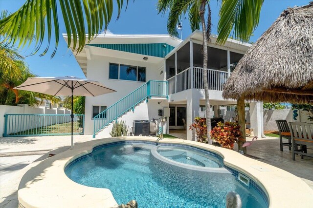 view of swimming pool featuring a patio area and a sunroom