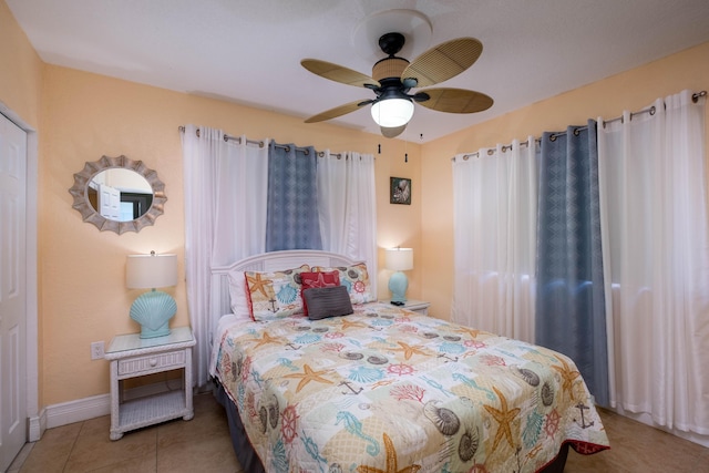 bedroom with baseboards, tile patterned flooring, and a ceiling fan