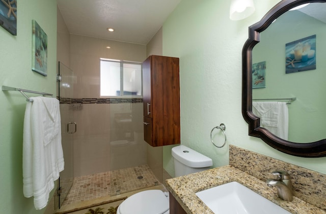 full bath featuring a stall shower, toilet, and vanity