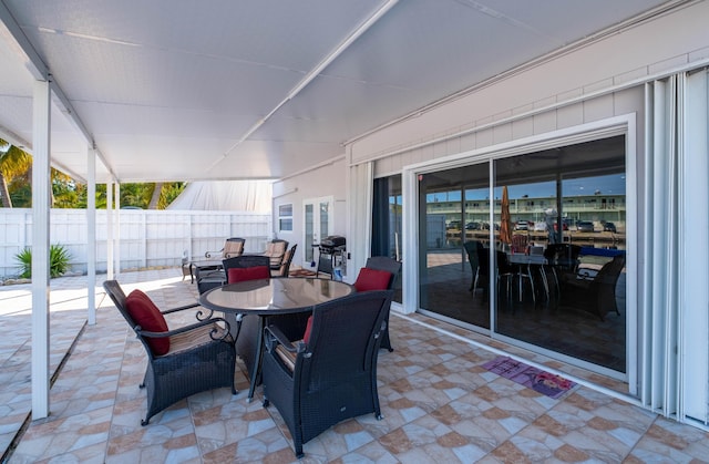 view of patio with outdoor dining area, area for grilling, and fence