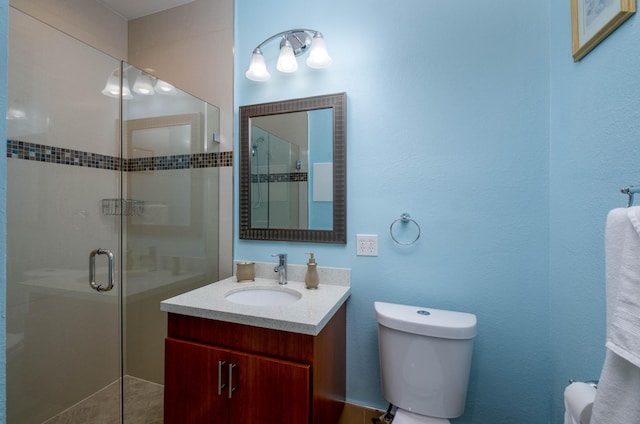 bathroom with toilet, vanity, and a stall shower
