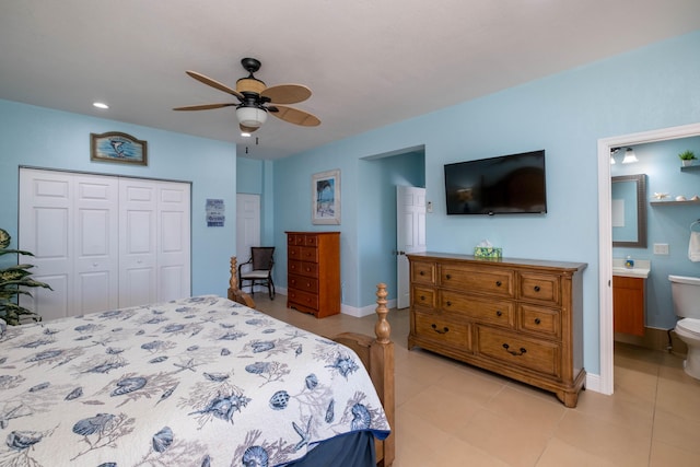 bedroom featuring a closet, light tile patterned floors, baseboards, ceiling fan, and ensuite bathroom