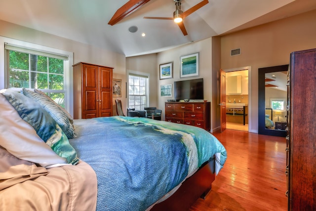 bedroom with lofted ceiling, a ceiling fan, visible vents, and wood finished floors