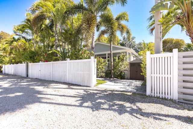 view of gate featuring fence private yard, an outbuilding, and a shed