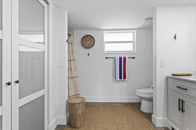 bathroom featuring hardwood / wood-style flooring, vanity, and toilet