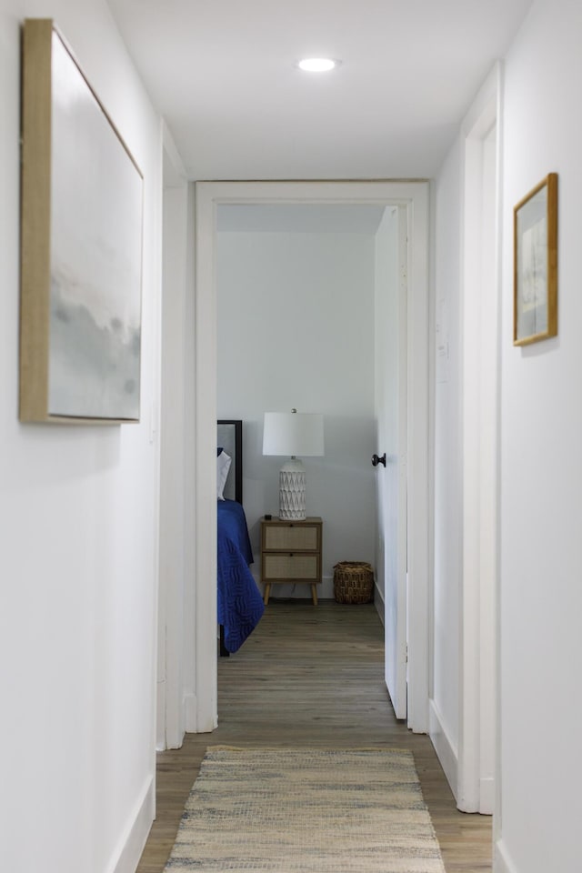 hallway with hardwood / wood-style flooring