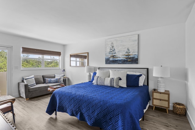 bedroom with wood-type flooring and multiple windows