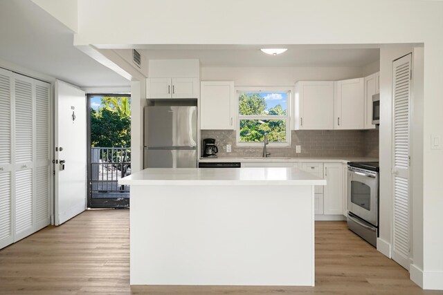 kitchen with a kitchen island, white cabinetry, appliances with stainless steel finishes, and sink