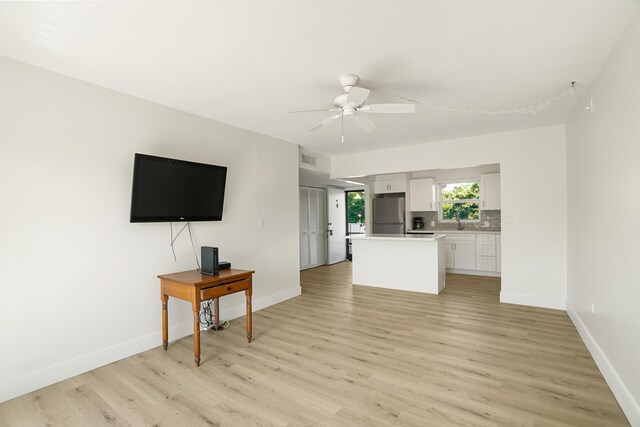 living room featuring sink, light hardwood / wood-style flooring, and ceiling fan