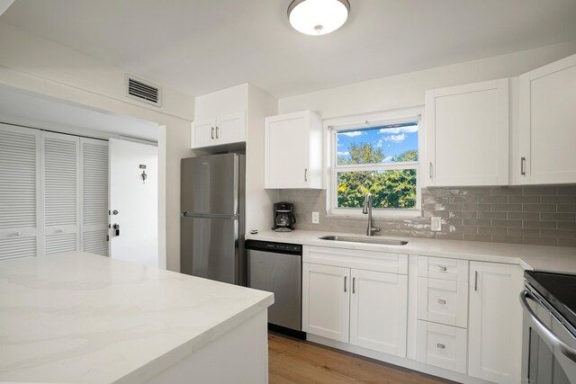 kitchen with white cabinetry, stainless steel appliances, and sink