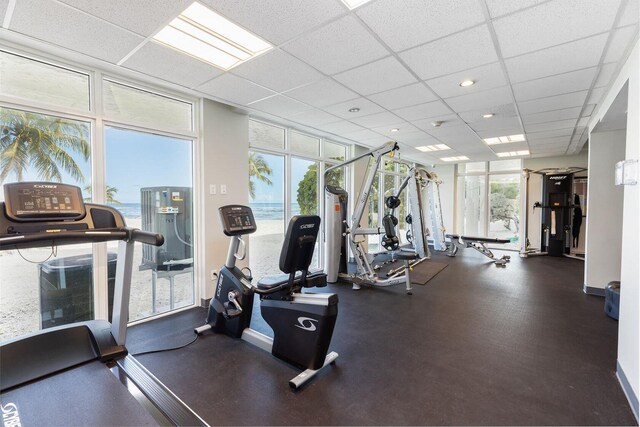 workout area with a drop ceiling and expansive windows