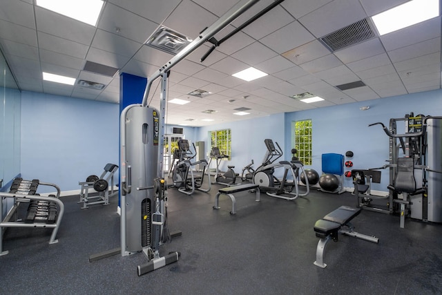 exercise room featuring visible vents, baseboards, and a drop ceiling