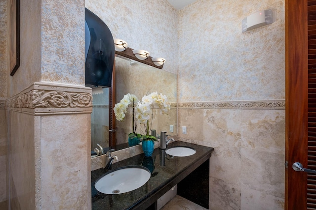 full bathroom with a sink and double vanity