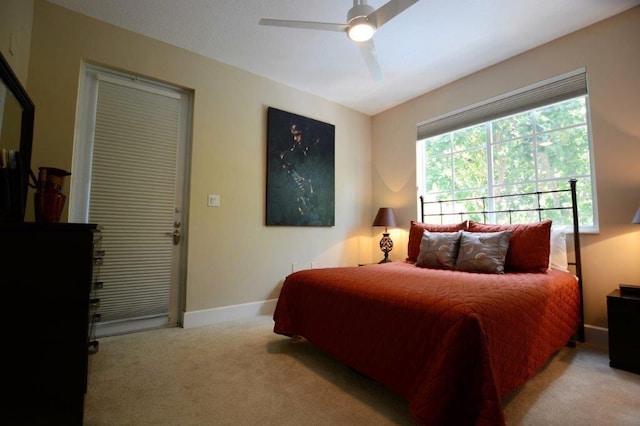 carpeted bedroom with ceiling fan and baseboards