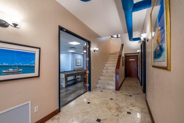 hallway featuring visible vents, stairs, and baseboards