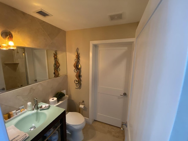 bathroom with tasteful backsplash, visible vents, toilet, and vanity