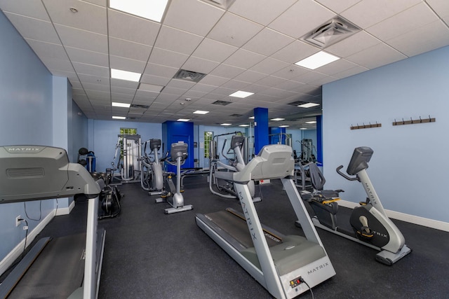 gym with visible vents, baseboards, and a drop ceiling