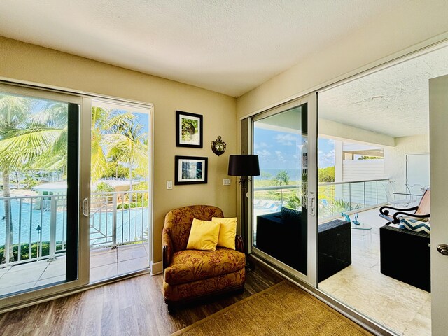 sitting room with a textured ceiling and wood finished floors