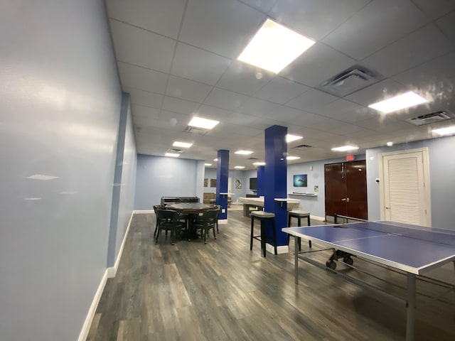 recreation room with visible vents, a paneled ceiling, baseboards, and wood finished floors