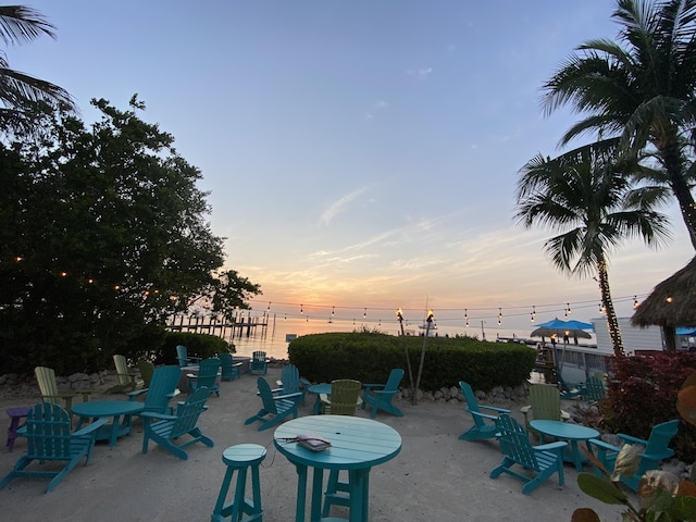 patio terrace at dusk featuring a water view