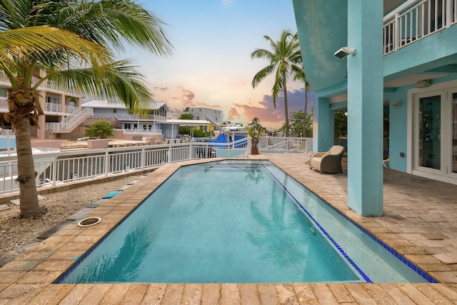 107 Hilson Ct, Tavernier, FL 33070 - pool at dusk featuring a fenced backyard and a patio