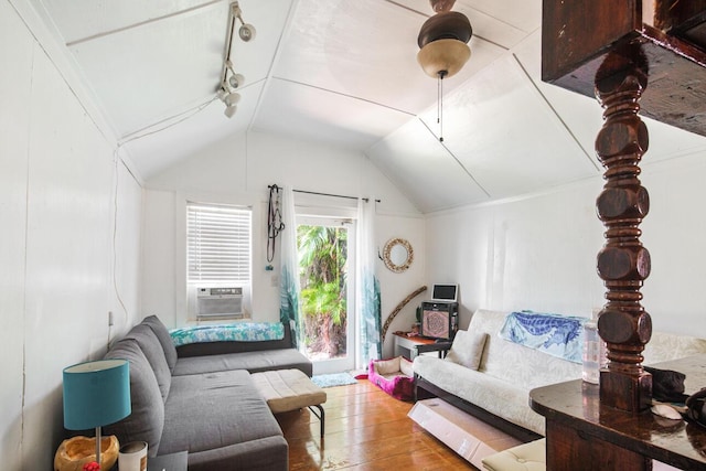 living room featuring cooling unit, lofted ceiling, rail lighting, and hardwood / wood-style floors