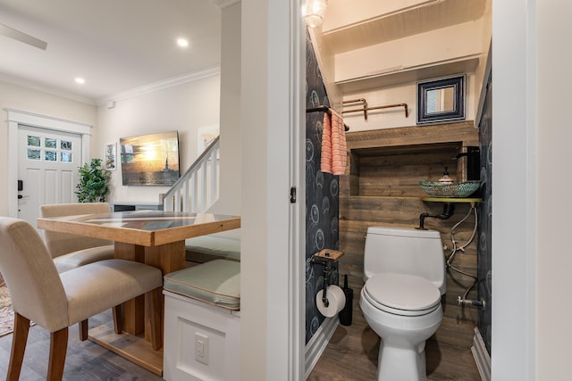 bathroom with crown molding, toilet, and hardwood / wood-style floors