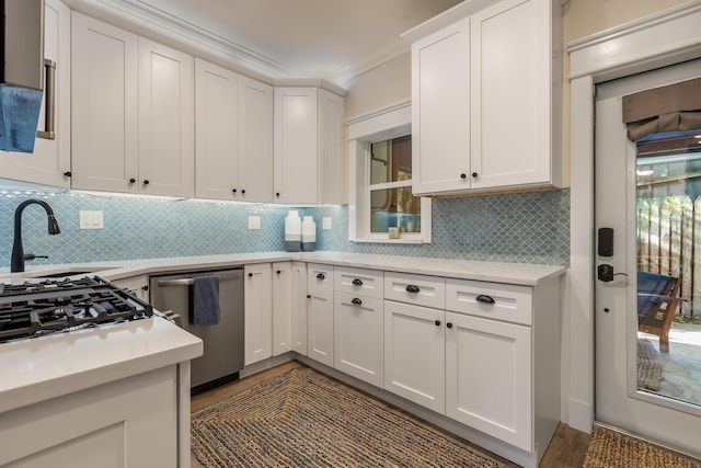 kitchen featuring sink, ornamental molding, dishwasher, decorative backsplash, and white cabinets