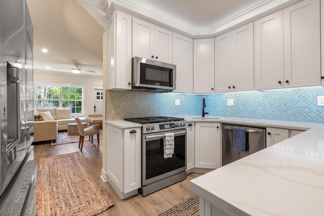 kitchen featuring white cabinetry, ornamental molding, and stainless steel appliances