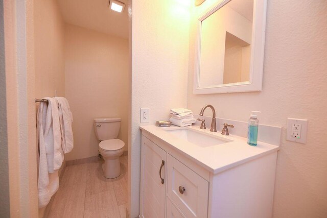 156 Marine Ave, Tavernier, FL 33070 - bathroom featuring toilet, vanity, wood finished floors, and baseboards