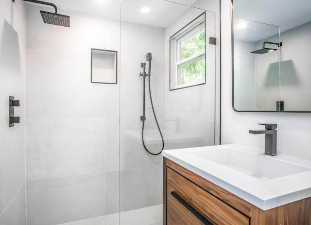 bathroom with vanity and a tile shower