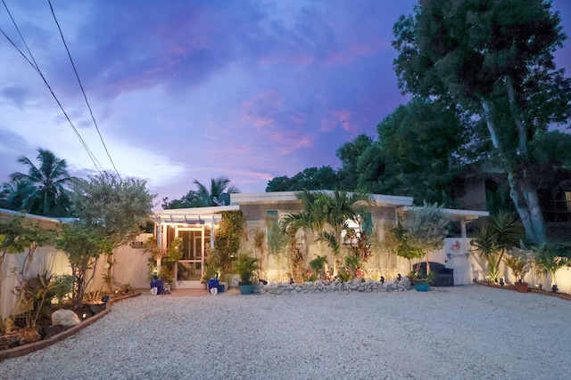 view of front facade featuring fence, driveway, and stucco siding