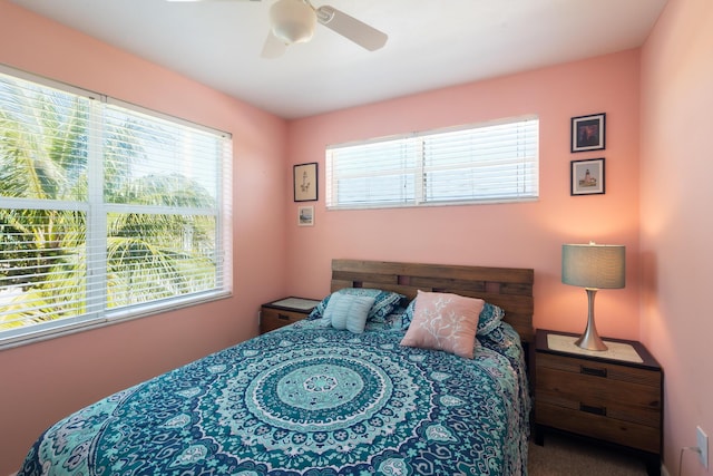 carpeted bedroom featuring ceiling fan and multiple windows