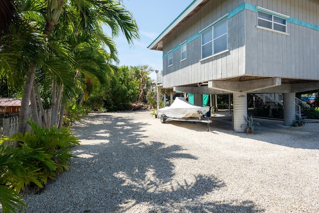view of home's exterior featuring stairs and gravel driveway