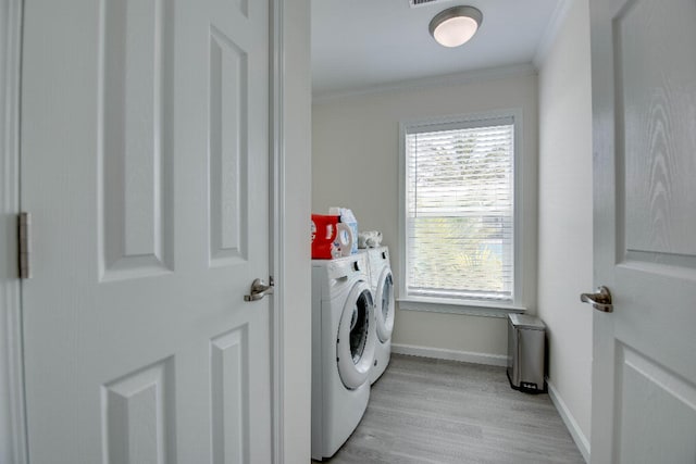 laundry room featuring independent washer and dryer, crown molding, laundry area, light wood-style flooring, and baseboards