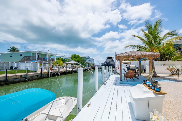 dock area featuring a water view, fence, and a gazebo