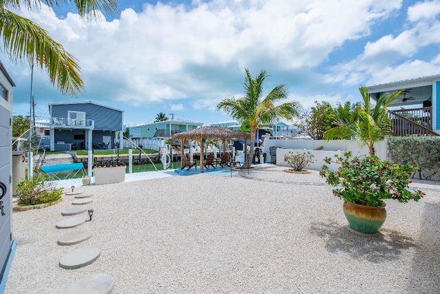exterior space with fence, a boat dock, boat lift, and a gazebo