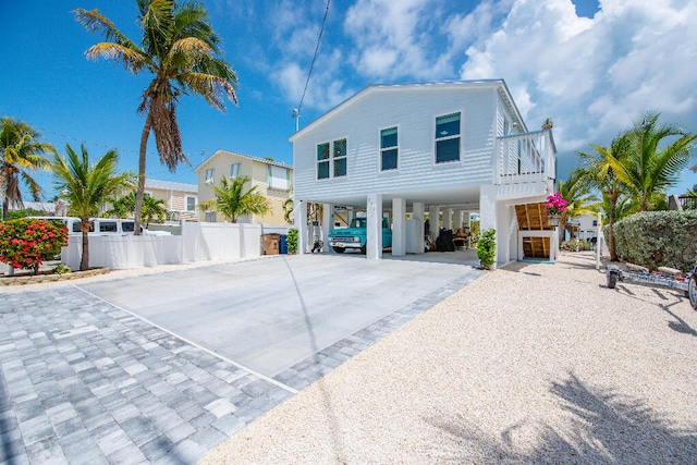 view of side of property featuring fence, driveway, and a carport