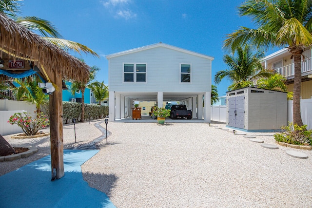 rear view of house with fence and a carport