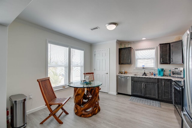 kitchen featuring visible vents, light countertops, light wood finished floors, and stainless steel appliances