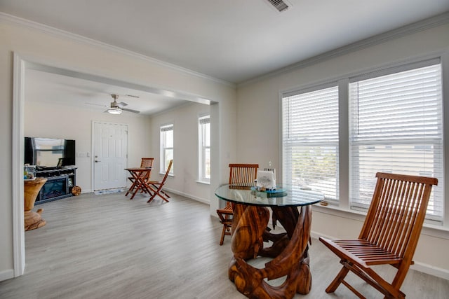 dining area with visible vents, ornamental molding, light wood finished floors, and baseboards