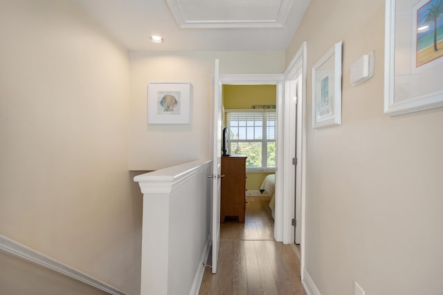 corridor with baseboards, wood finished floors, and an upstairs landing