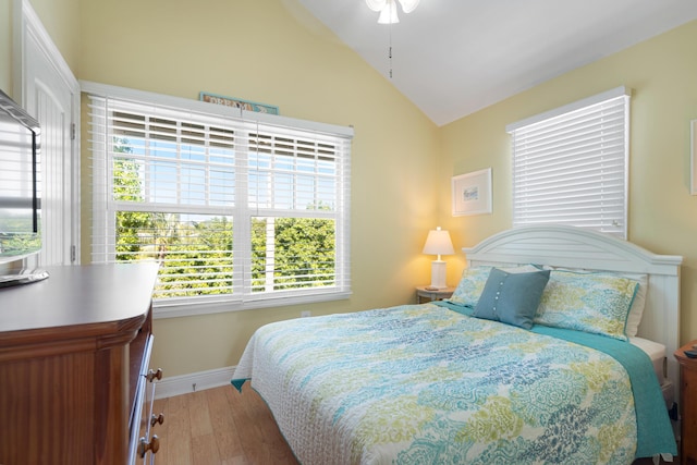 bedroom featuring vaulted ceiling, baseboards, and wood finished floors