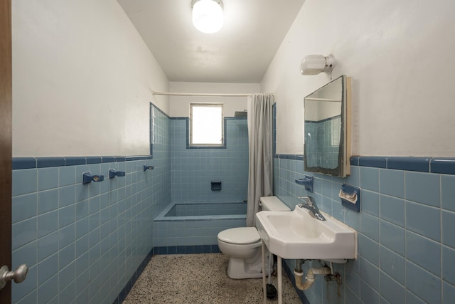 full bathroom with shower / bath combination with curtain, toilet, sink, and tile walls