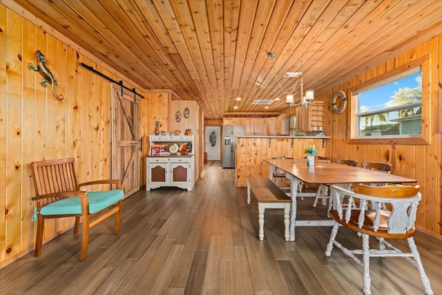 dining area with wood ceiling, a barn door, dark hardwood / wood-style flooring, and wood walls