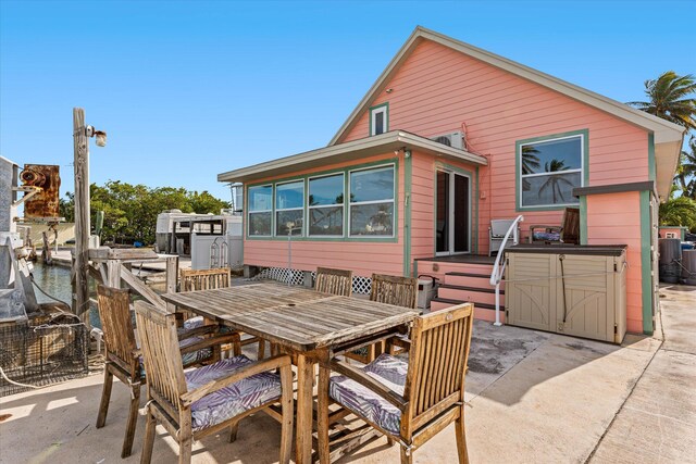 back of property featuring a hot tub and a patio