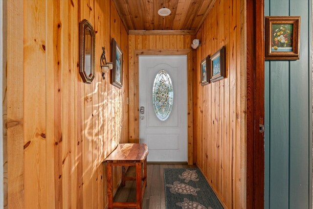 entryway with dark wood-type flooring, wooden walls, and wooden ceiling